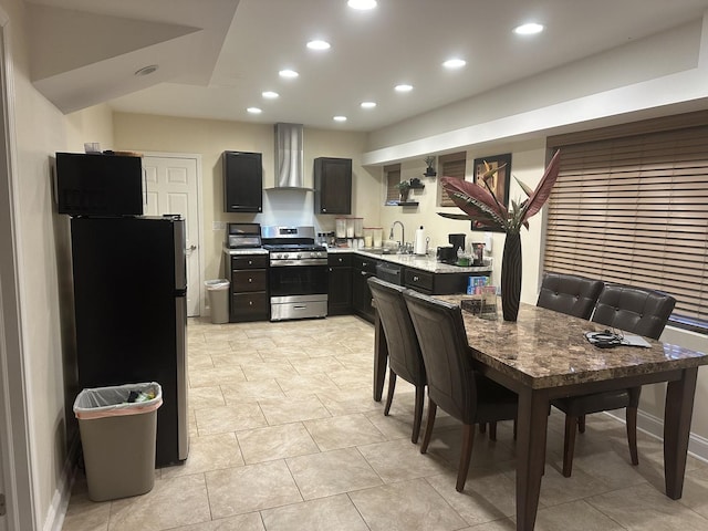 kitchen with light countertops, recessed lighting, wall chimney exhaust hood, and stainless steel appliances