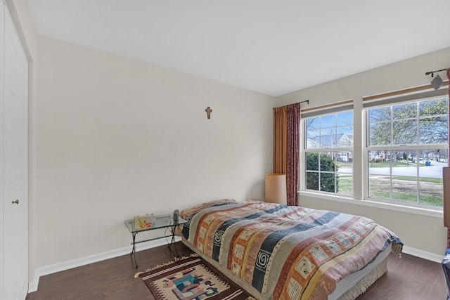 bedroom with baseboards and wood finished floors