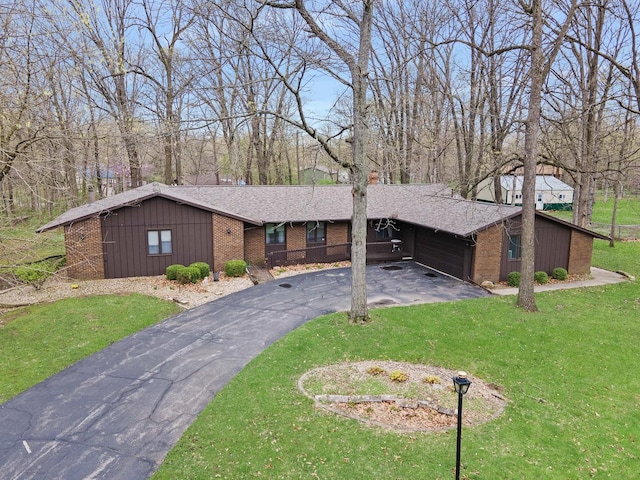 view of front of home with brick siding, a front lawn, driveway, and a garage