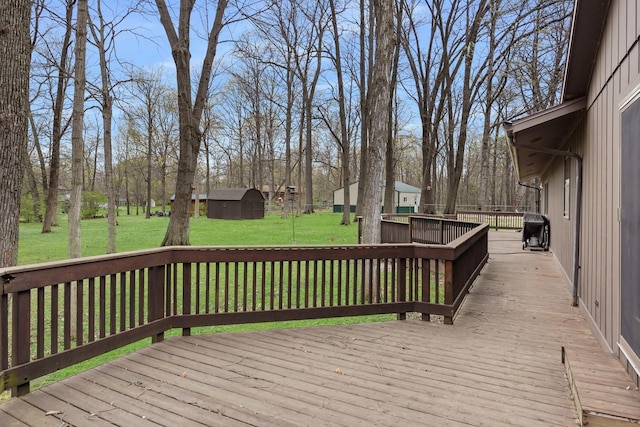 deck with grilling area, a storage unit, a yard, and an outbuilding