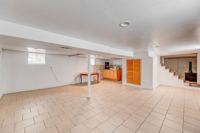 basement with baseboards and stairs