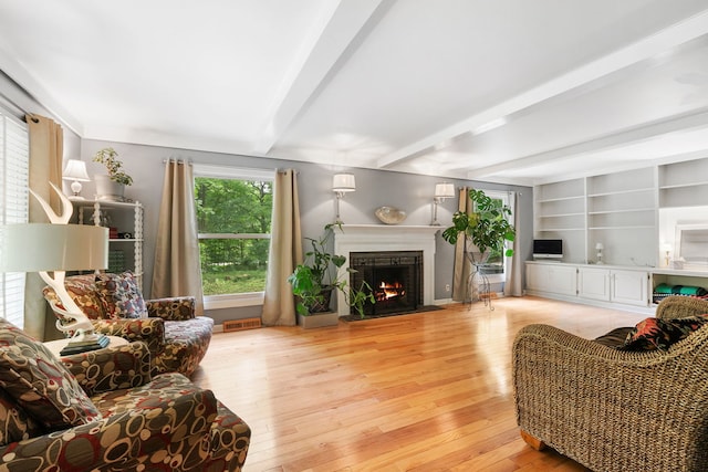 36W525 Wild Rose Rd, Saint Charles, IL 60174 - living area with beamed ceiling, a fireplace with flush hearth, and light wood-type flooring
