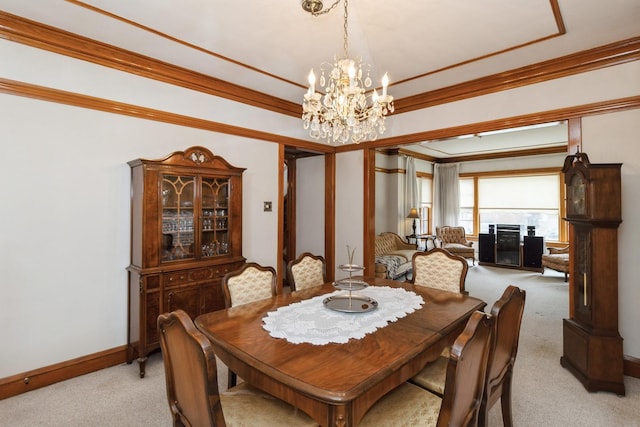 dining space with light colored carpet, a notable chandelier, crown molding, and baseboards
