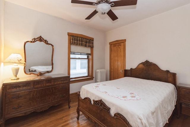 bedroom featuring radiator heating unit, a ceiling fan, and wood finished floors