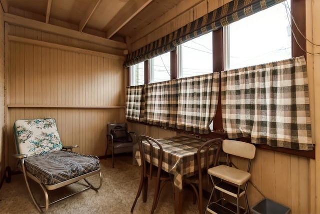 sitting room with carpet flooring and wood walls