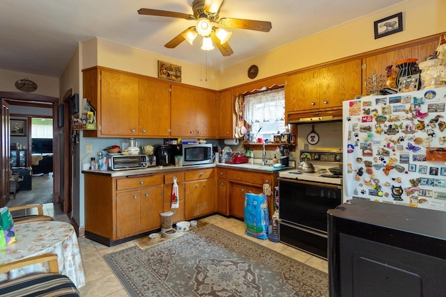 kitchen featuring brown cabinets, range with electric stovetop, ceiling fan, and stainless steel microwave