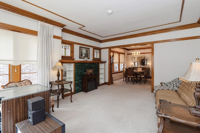 living room with a fireplace, ornamental molding, a baseboard heating unit, carpet floors, and a notable chandelier