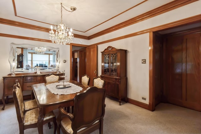 dining room with an inviting chandelier, light carpet, crown molding, and baseboards