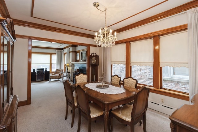 dining space with crown molding, carpet flooring, a chandelier, a fireplace, and a baseboard heating unit