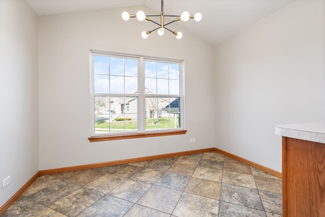 2442 Wilton Ln Unit 2442, Aurora, IL 60502 - empty room with vaulted ceiling, stone finish flooring, baseboards, and a chandelier