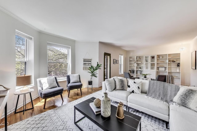 living area with crown molding and wood finished floors