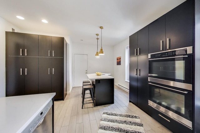kitchen featuring stainless steel appliances, light countertops, light wood-type flooring, a center island, and a kitchen breakfast bar