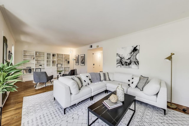 living room featuring wood finished floors and crown molding