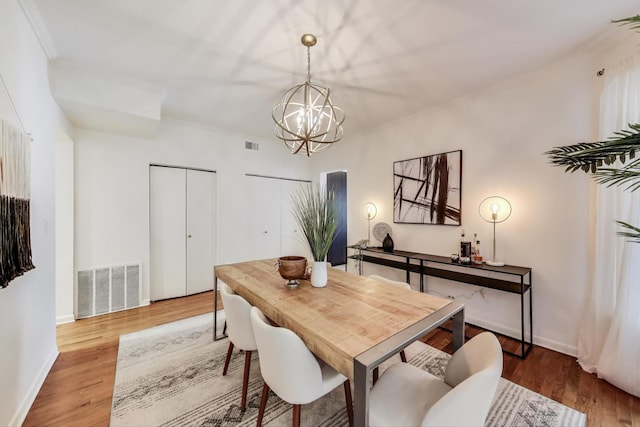 dining area with a chandelier, light wood-type flooring, and baseboards
