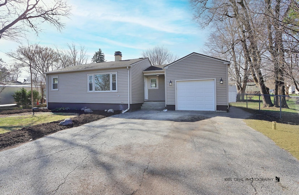 409 Nippersink Dr, Mchenry, IL 60051 - single story home featuring aphalt driveway, an attached garage, fence, and a chimney