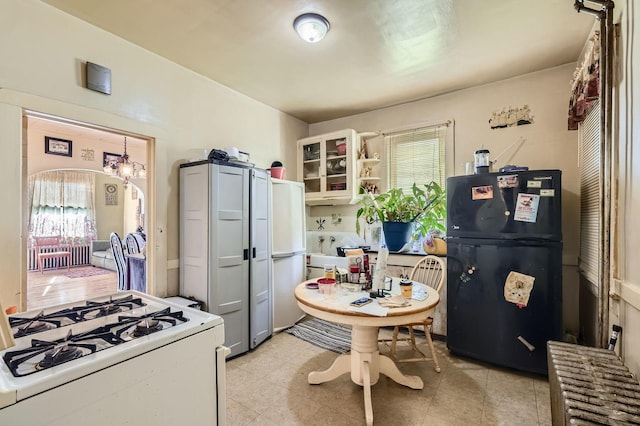 1506 Shields Ave, Chicago Heights, IL 60411 - kitchen featuring a chandelier, glass insert cabinets, and white appliances