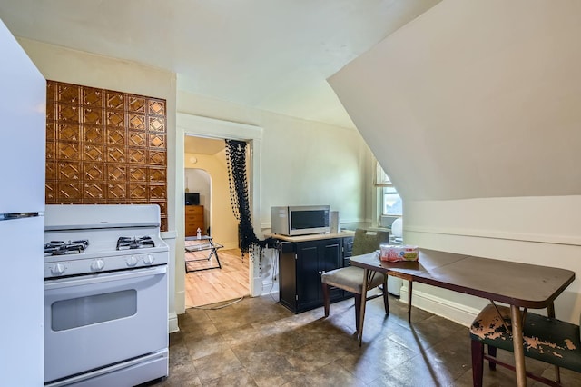 1506 Shields Ave, Chicago Heights, IL 60411 - kitchen with dark cabinetry, white appliances, arched walkways, and lofted ceiling