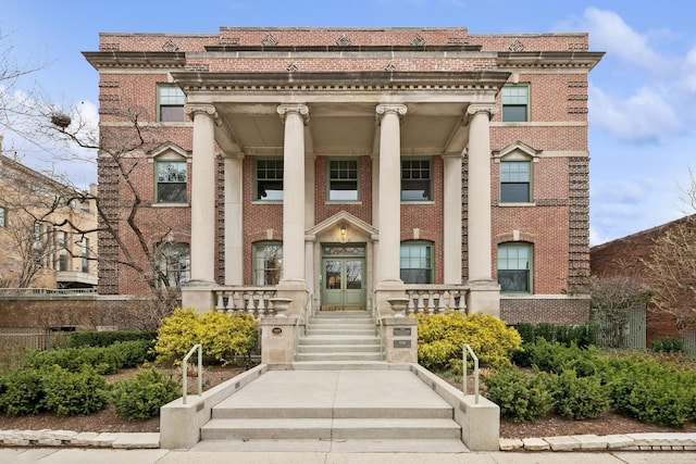 view of front facade featuring brick siding and a porch
