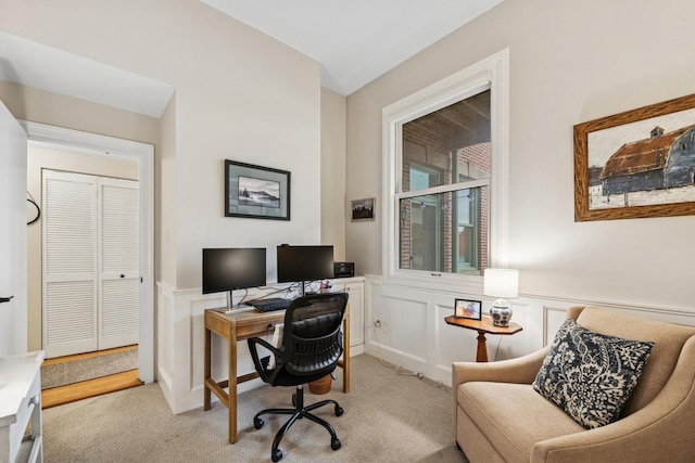 office area with light carpet, a wainscoted wall, and a decorative wall