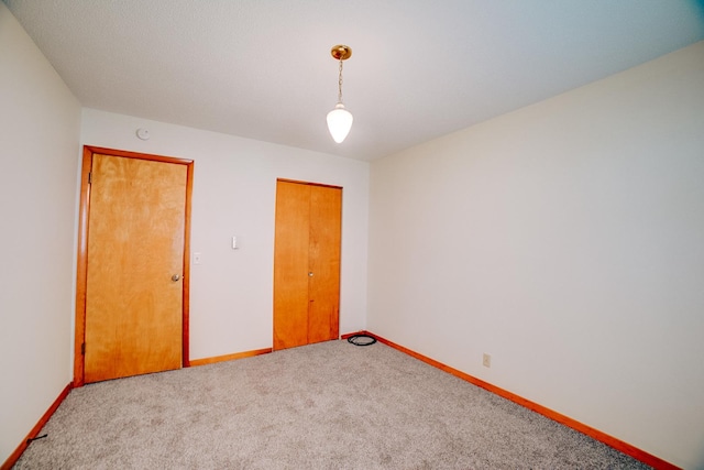 unfurnished bedroom featuring carpet floors and baseboards