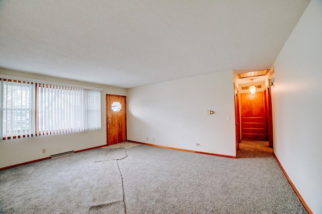 spare room with baseboards, visible vents, carpet floors, and a textured ceiling