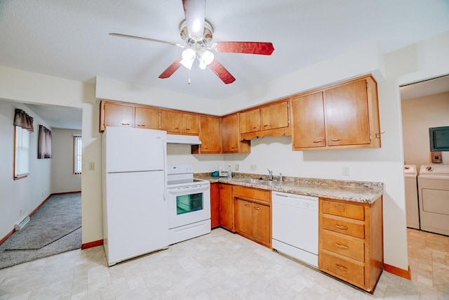 kitchen with white appliances, under cabinet range hood, washing machine and clothes dryer, a sink, and ceiling fan