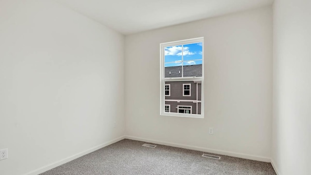 carpeted empty room featuring visible vents and baseboards
