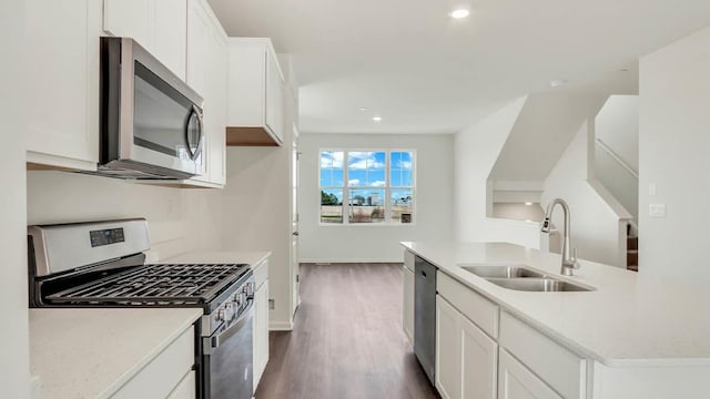 kitchen featuring white cabinets, a sink, appliances with stainless steel finishes, dark wood-style floors, and recessed lighting