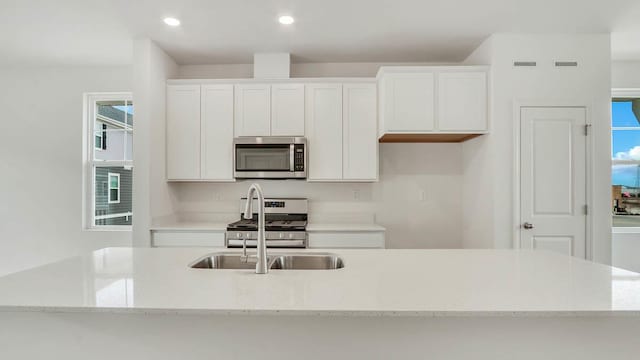 kitchen with stainless steel appliances, plenty of natural light, white cabinetry, and recessed lighting