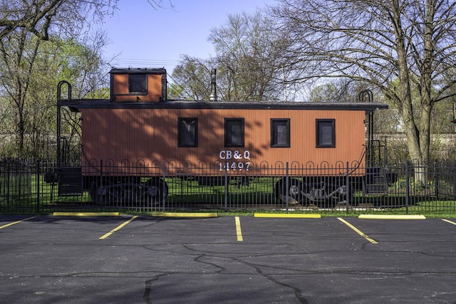 view of property featuring fence and uncovered parking