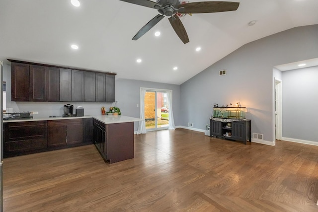 kitchen with light countertops, visible vents, a peninsula, dark brown cabinets, and open floor plan