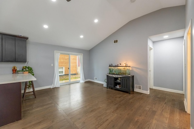 interior space with dark wood-style floors, visible vents, lofted ceiling, and baseboards