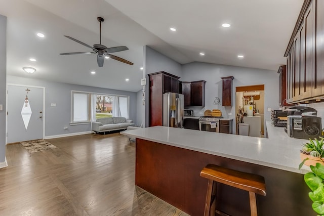 kitchen with light countertops, a peninsula, ceiling fan, stainless steel appliances, and open floor plan