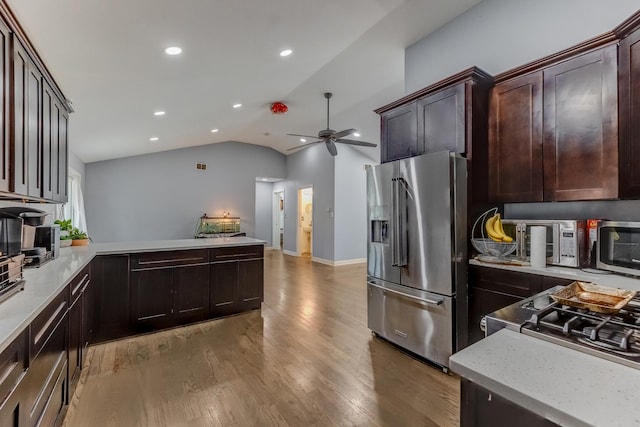 kitchen with lofted ceiling, light wood-type flooring, high end refrigerator, a ceiling fan, and a peninsula