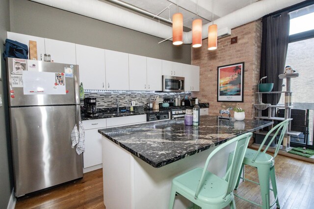 kitchen featuring a sink, white cabinets, stainless steel appliances, and dark wood-style flooring