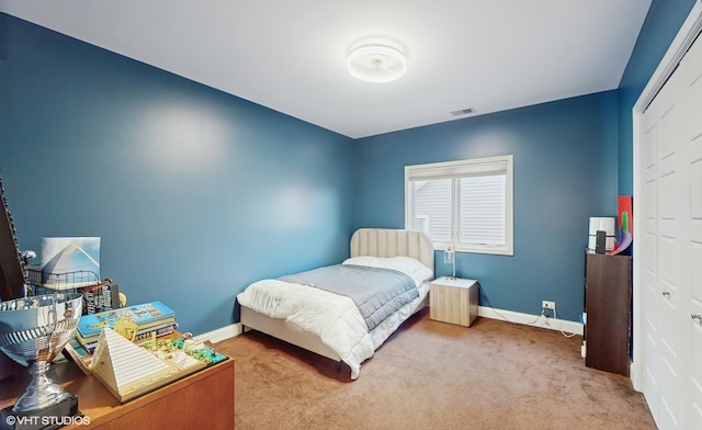 carpeted bedroom featuring a closet, baseboards, and visible vents