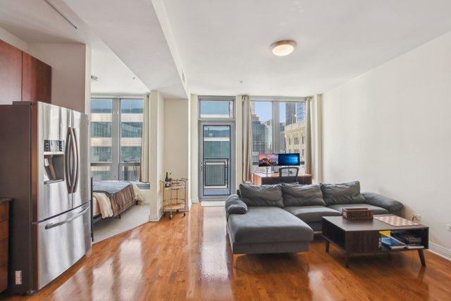 565 W Quincy St Unit 1711, Chicago, IL 60661 - living room with a wall of windows, light wood-type flooring, baseboards, and a healthy amount of sunlight