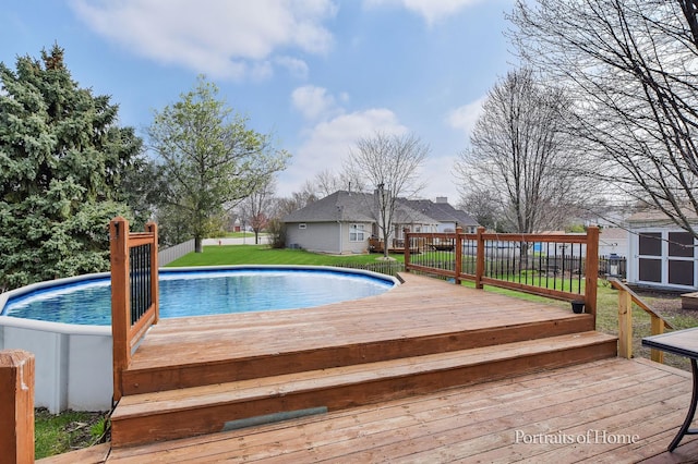 view of swimming pool featuring a fenced in pool, a wooden deck, a yard, and fence