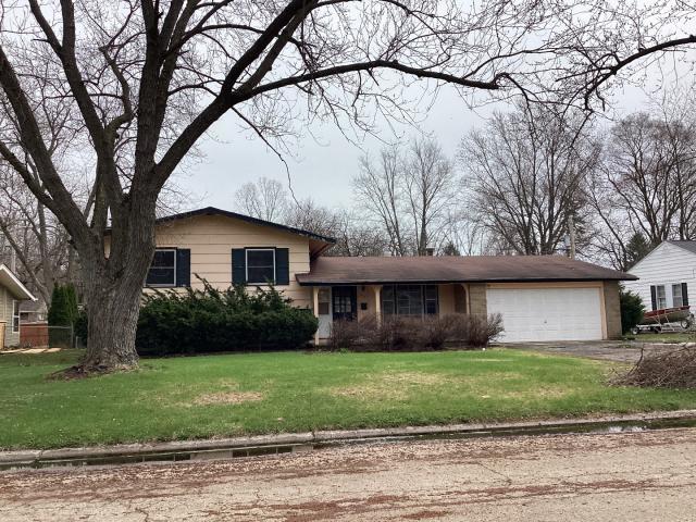 view of front of home with driveway, a front yard, and a garage