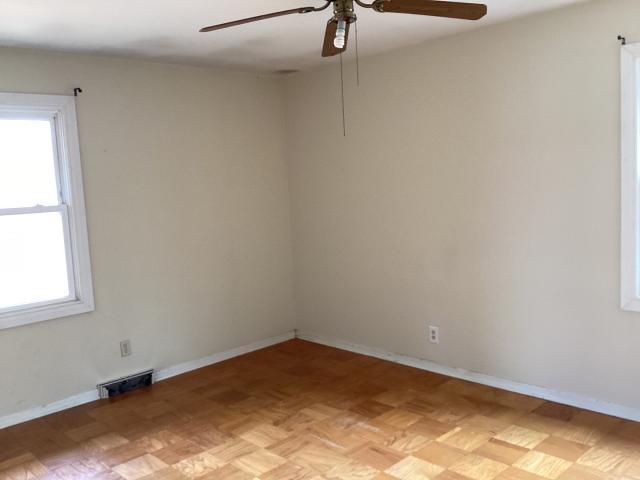 unfurnished room with baseboards, visible vents, and ceiling fan