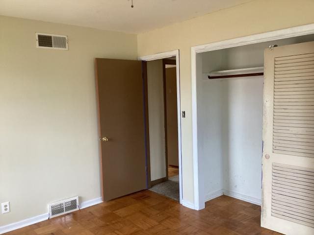 unfurnished bedroom with a closet, baseboards, and visible vents