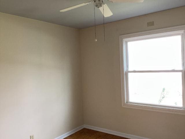 empty room featuring baseboards and ceiling fan