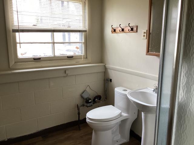 half bath with toilet and wood finished floors