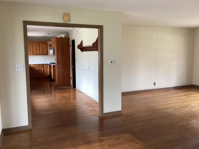 unfurnished room featuring dark wood-style floors and baseboards