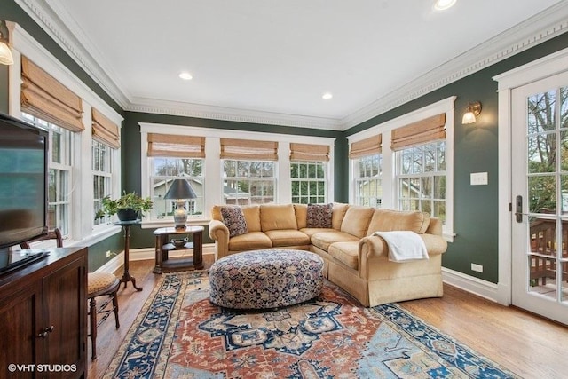 sunroom / solarium featuring wood finished floors, crown molding, and a healthy amount of sunlight