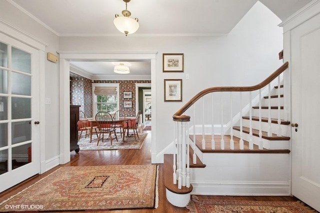 entrance foyer with wood finished floors, baseboards, ornamental molding, and stairway