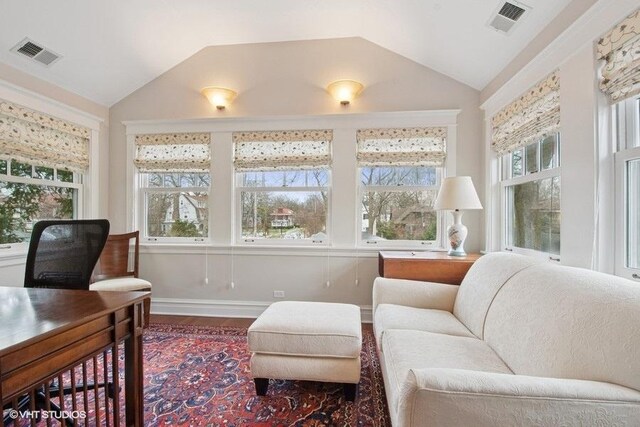 interior space featuring visible vents, baseboards, wood finished floors, and lofted ceiling
