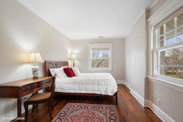 bedroom featuring dark wood-style flooring, visible vents, baseboards, and crown molding