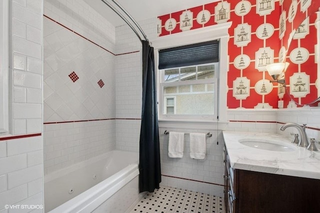 full bath with tile walls, shower / bath combo with shower curtain, vanity, and a wainscoted wall