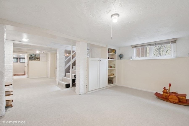 basement with stairway, carpet, a textured ceiling, and baseboards